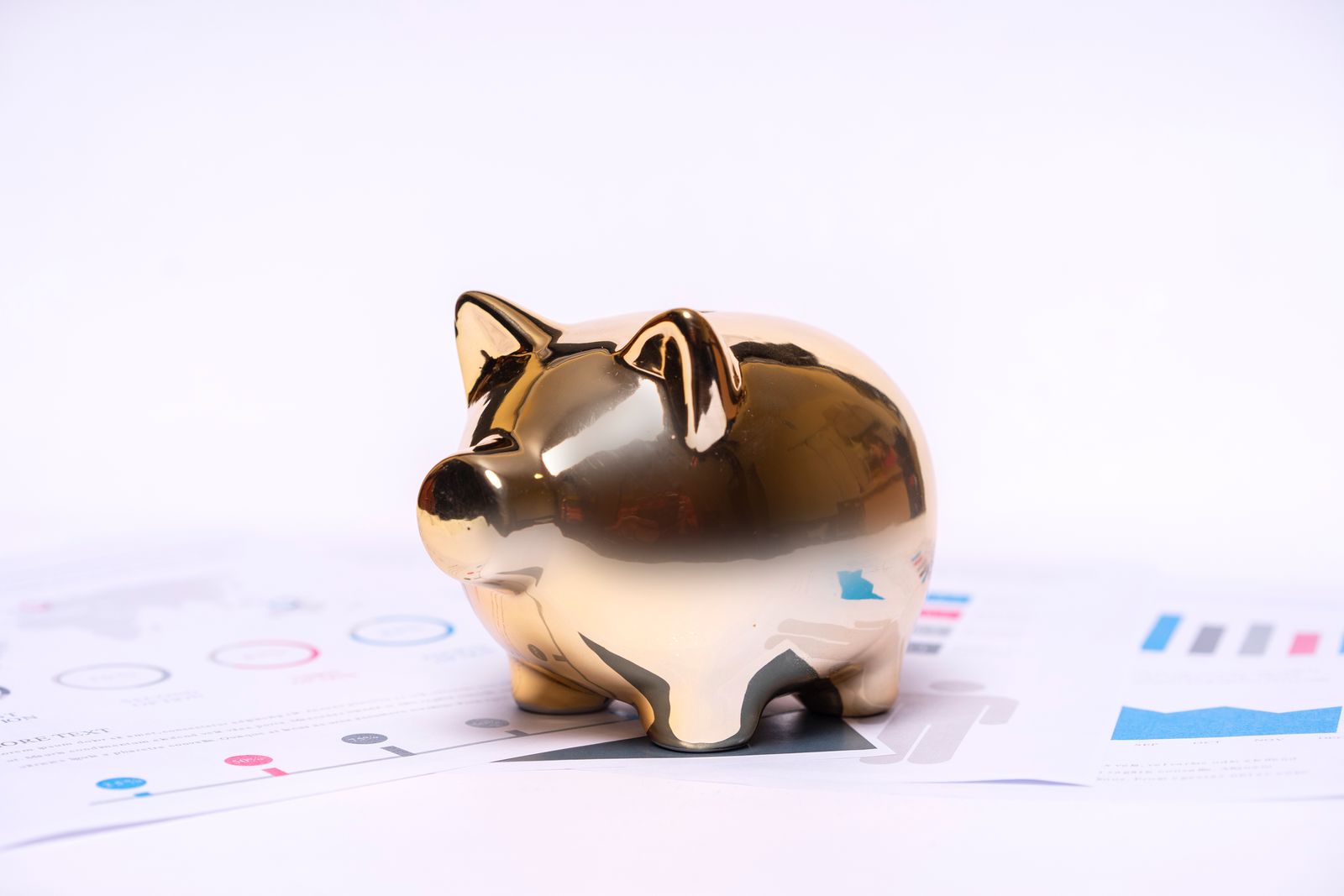 Golden piggy bank resting on financial documents