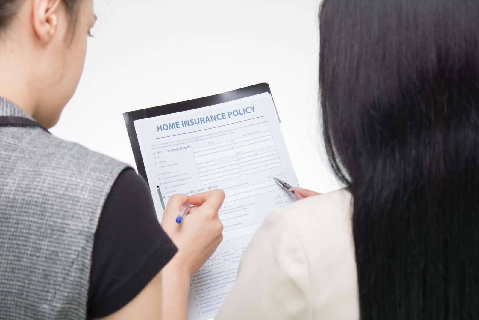 Two women carefully reviewing an insurance policy form